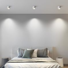 a white bed sitting in a bedroom next to two lamps on either side of it