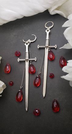 More coming soon! restocking in progress!  These gothic sword earrings add a dark flare to any outfit.  Originally designed and hand made for this shop!  These earrings are on the larger side. Lenght: 4.5in Blood Drip Earrings, Gothic Piercings Earrings, Ren Faire Earrings, Vampire Goth Jewelry, Long Dangling Earrings, Dark Fantasy Jewelry, Romantic Goth Jewelry, Ghotic Jewelry, Cute Accessories Aesthetic