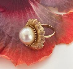 Kālā (the Sun) Spectacular 14mm Natural Color Champagne South Sea Cultured Pearl Ring, Size 7. What an incredible statement piece, 18k Yellow Gold plating over 925 Sterling Silver with an amazing high luster cultured pearl set inside. Measuring 1" in length. The cultured pearl is 14mm size, natural color Champagne and origin is the South Sea, Philippines. Non-resizable 18k Yellow Gold plated over 925 Sterling Silver ring in US ring size 7. Check our shop also for the Kālā pendant if you want a matching set. Only one in stock! Pearl Type: Golden South Sea Cultured  Pearl Treatment: No Treatment   Pearl Size: 14mm Pearl Color: Natural Color Champagne  Pearl Origin: Philippines, South Sea  Metal Type: 18k Yellow Gold plated over 925 Sterling Silver  US Ring Size: 7 Manufactured in Kailua, Haw Cultured Pearl Ring, Buy Pearls, Golden South Sea Pearls, Pearl Shop, Color Champagne, South Seas, Pearl Set, South Sea Pearls, Pearl Types