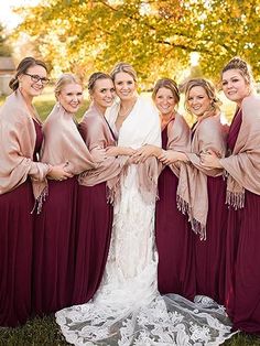 a group of women standing next to each other on top of a grass covered field