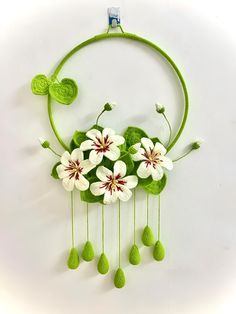 a group of flowers hanging from the side of a green circle with leaves on it