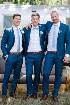 three men in blue suits posing for the camera