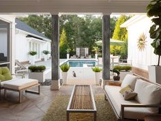 an outdoor living area with couches, tables and chairs