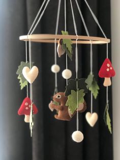 a mobile made out of felt with mushrooms and leaves hanging from it