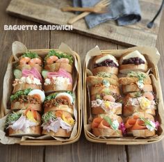 two baskets filled with sandwiches on top of a wooden table