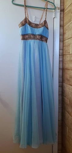 a blue dress hanging on a clothes rack