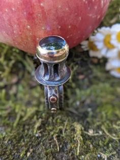 A swiss blue topaz set in a gold bezel sits up high on this ring. The stone is sitting on top of a cast shark vertebrae. The only cast element on this ring, everything else is fabricated. The band has a lot of details. It is a combination of sterling silver and 14k yellow gold. There are 8 gold dots around the shank. The ring is measuring around a 5 3/4 - 6. It cannot be sized. I've given the whole piece an overall oxidizing to give a darker appearance. Mixed Metal Rings, Bold Rings, Hessonite Garnet, Spike Earrings, Gold Dots, Swiss Blue Topaz, Mixed Metals, Metal Rings, Sterling Ring