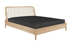 a wooden bed frame with black sheets on it