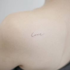 a woman's back with the word love tattooed on her left side ribcage