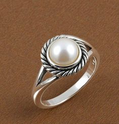 Add a touch of classic elegance to your look with our Round Pearl Silver Ring. This beautiful ring features a smooth, round pearl set in a sleek silver band. Its timeless design makes it perfect for everyday wear or special occasions. Crafted from high-quality silver, the ring showcases the pearl's natural shine, making it a lovely addition to any jewelry collection. Simple yet stunning, it's a perfect choice for a refined and sophisticated style. DETAILS---- 1) Material - 925 Silver 2) Gemstone Classic Round Rings With Pearl Drop, Classic Pearl Ring With Pearl Drop, Classic Round Pearl Ring With Pearl Drop, Timeless Silver Sterling Silver Pearl Ring, Timeless Sterling Silver Pearl Ring In Silver, Timeless Silver Pearl Ring In Sterling Silver, Classic Pearl White Open Ring, Elegant White Pearl Ring With Round Band, Elegant White Pearl Ring