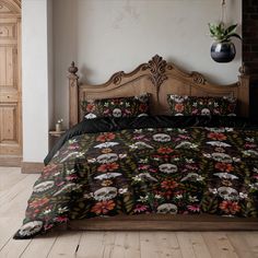 a bed with skulls and flowers on it in a room next to a brick wall