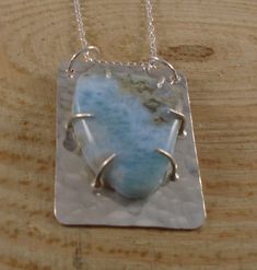 A pretty, statement necklace, hand made from sterling silver. A rectangle of silver has been hand pierced from a sheet. It has then been hammered to give a dimpled texture. Wire claws have then been soldered on to hold a Larimar gemstone, and two hole has been drilled in the top for loops for the chain. Pendant size approx 3.5x2.5cm Comes on an 18 inch sterling silver chain Comes in a presentation box Please take a look at my other items Hand Piercing, Claw Earrings, Larimar Necklace, Spoon Necklace, Silverware Jewelry, Larimar Pendant, Hammered Silver, Earrings Photo, Handmade Jewellery