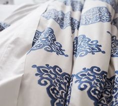 an unmade bed with blue and white sheets