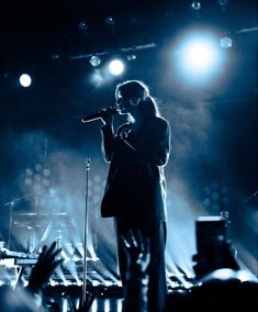 a man standing on top of a stage holding a microphone