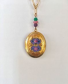 "New Old Stock ~ Like new condition. This vintage oval locket has a beautiful heavy gold plate and is hand enameled. Pretty complimentary Czech glass beads and glass crystal accent the colors of the enamel. The locket opens and closes securely to hold a treasured picture or small object. It measures 3/4\" wide and 1\" long and hangs from a gold plated 14K 16 inch signed Lucy Isaacs chain. Thank you for visiting Lucy Isaacs Jewelry here at our online store. To view all of my vintage Czech glass i Oval Enamel Locket Jewelry, Oval Enamel Locket Necklace, Oval Locket Necklace In Enamel, Vintage Enamel Oval Pendant Jewelry, Antique Oval Enamel Necklaces, Antique Oval Enamel Necklace, Hand Painted Oval Enamel Jewelry, Vintage Oval Enamel Jewelry, Gold Oval Enamel Jewelry