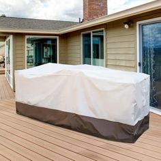 a covered patio area with sliding glass doors and wooden flooring on the side of a house