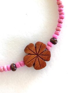 Darling little hand carved genuine Hawaiian Koa wood flower beaded with tiny dust rose pink vintage African glass beads and .925 sterling silver clasp. Koa wood plumeria flower is 1/2inch and beaded with 3-4mm vintage African trade beads in sweet dusty pink color. Necklace is 15 1/2 inches plus 2 Inch extension. Spring ring clasp and all findings are .925 sterling silver. Choker also available in aqua, orange and yellow. Adjustable Pink Flower Necklace, Pink Wooden Beads Necklace For Gift, Pink Wooden Beaded Necklaces For Gifts, Pink Handmade Adjustable Flower Necklace, Handmade Adjustable Pink Flower Necklace, Adjustable Pink Flower Necklace With Round Beads, Adjustable Flower Necklace, Adjustable Pink Bohemian Flower Necklace, Pink Flower Beaded Necklaces For Beach