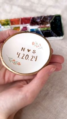 a person holding a small white plate with the word nvs 1201 printed on it