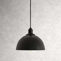 an industrial style pendant light hanging from a black metal ceiling fixture against a white wall