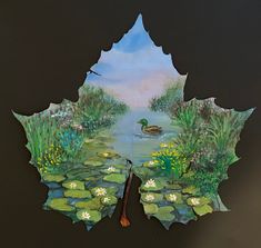 a leaf with a painting of a duck in the pond on it's side