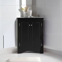 a black cabinet in a white tiled bathroom