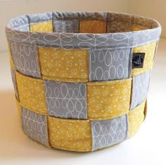 a yellow and gray basket sitting on top of a table