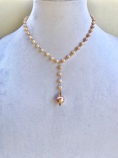 Beautiful and feminine pink hued pearl necklace with gold accents, and a large baroque pearl pendant. Elegant Pink Pearl Drop Necklace, Elegant Pink Pearl Necklace With Pendant, Pink Single Strand Baroque Pearl Necklace, Pink Baroque Pearl Single Strand Necklace, Lariat Necklace With Baroque Pearl Chain, Pink Baroque Pearl Necklace With Pearl Charm, Long Drop Pearl Necklace With Pearl Pendant, Long Drop Pearl Necklace With Pearl Charm, Elegant Pink Baroque Pearl Necklace