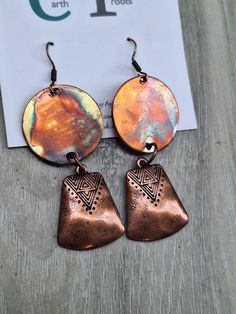 These boho style earrings are designed from copper circles 1" in diameter that have been fire painted using a propane torch to bring out the different colors in the metal. NOTE:  Certain lighting will bring the colors out  more than other types of lighting. (See photos) They are finished with copper bell-shaped dangles. The earrings measure just over 2.5" in length.  They will ship in a gift box or bag via USPS with tracking info provided. Nickel-free Bronze Artsy Earrings, Handmade Artistic Copper Earrings, Nickel-free Copper Artsy Jewelry, Artistic Handmade Copper Earrings, Multicolor Round Copper Jewelry, Artisan Orange Copper Earrings, Artsy Nickel-free Copper Jewelry, Earthy Copper Jewelry For Festivals, Artisan Metal Earrings In Rust Color