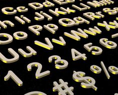 the letters and numbers are lit up with yellow light from below, on a black surface