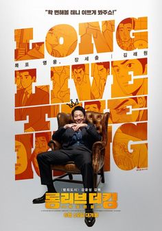 a man sitting on top of a chair in front of an orange and white poster