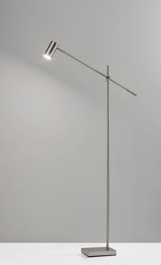 a lamp that is sitting on top of a white table next to a gray wall