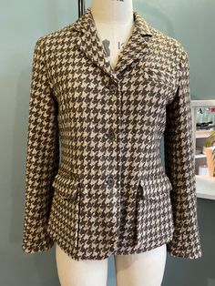 Gorgeous Tweed Riding Jacket in 100% wool with leather under collar and packet flaps Large Houndstooth pattern in brown on beige ground Riding jacket back belted detail and vent Bellows pockets and metal shank buttons Cool pinstriped lining Immaculate condition as hardly worn and a very flattering fit Wool Tweed Jacket With Flap Pockets And Lapel Collar, Wool Tweed Jacket With Lapel Collar And Flap Pockets, Brown Tweed Jacket With Welt Pockets For Work, Brown Tweed Workwear Jacket With Welt Pockets, Fall Sport Coat With Houndstooth Pattern And Suit Collar, Fall Houndstooth Sport Coat With Lapel Collar, Wool Outerwear With Houndstooth Pattern And Suit Collar, Wool Sport Coat With Flap Pockets For Fall, Wool Tweed Jacket With Houndstooth Pattern And Lapel Collar