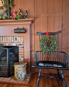 a chair with a wreath on it next to a fire place