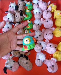 someone is holding their hand out in front of small crocheted animals