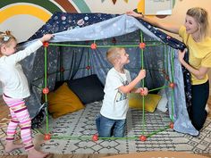 two girls and a boy playing in a play tent