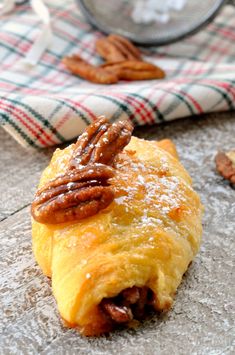 there is a pastry with pecans on the top and other food in the background