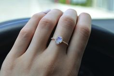 a woman's hand with a ring on it and a car steering wheel in the background