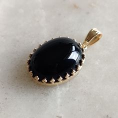 This stunning Pendant is set in 14k Solid Yellow Gold with Natural Black Onyx with utmost precision. It is a unique gemstone Pendant for nearly every occasion and is completely hassle-free jewelry. ITEM DETAILS: * GEM: Black Onyx * GEM SIZE: 12x16mm * GEM SHAPE: Oval * Gem weight: 10.30 carats * Gold Purity: 14KT (58.33% approx.) * Gold Weight: 1.3 gram * Total Weight of the Pendant: 3.36 gram The Gold purity is guaranteed and it comes with authentic 14KT gold hallmark. Since my items are handmade, they are absolutely nickel and lead free. CUSTOMIZATION: * Gemstone customization is available and it can be substituted with a gem of your choice. Kindly message me for the same. PACKAGING * The Pendant comes with layers of safe and secure wrapping along with Free handmade jewelry box with ever Elegant Onyx Oval Cabochon Jewelry, Elegant Oval Cabochon Onyx Jewelry, Elegant Oval Black Enamel Jewelry, Formal Oval Onyx Jewelry, Timeless Round Onyx Jewelry, Classic Onyx Oval Cabochon Jewelry, Timeless Oval Black Enamel Jewelry, Formal Onyx Oval Cabochon Jewelry, Oval Onyx Fine Jewelry