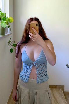 a woman taking a selfie with her cell phone in front of her face and wearing a blue bra