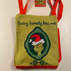 a green and red bag with an elf's hat on it that says, every family has one