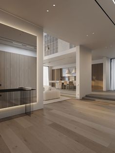 an empty living room with wooden floors and white furniture in the center is lit by recessed lights