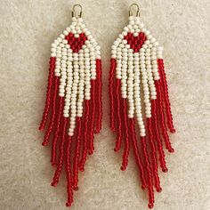 two pairs of red and white beaded earrings with fringes hanging from the ends