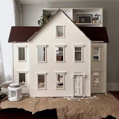 a doll house sitting on top of a piece of cardboard