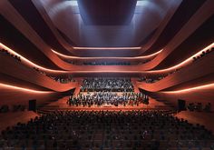 an auditorium filled with lots of people standing on the side of it's walls