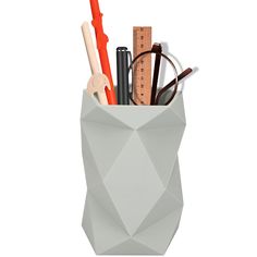 a pencil holder with scissors, rulers and other items in it