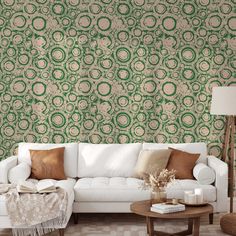 a white couch sitting in front of a green wallpapered living room filled with furniture