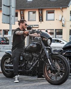 a man sitting on top of a black motorcycle