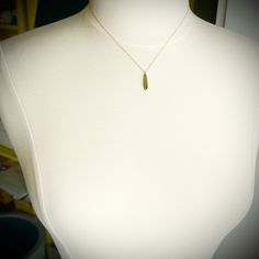 An slim teardrop of deep green, rose cut tourmaline is wrapped in warm 22k gold. Backed with sterling silver and suspended from a delicate 14k gold chain. Simple and so elegant. Pendant measures approximately 3/8 inch in length. Matte finish. Minimalist Gold Emerald Necklace In Sterling Silver, Gold Briolette Emerald Necklace Gift, Gold Faceted Drop Necklace, Gold Faceted Briolette Drop Necklace, Yellow Gold Long Drop Necklace For Gift, Gold Teardrop Wire Wrapped Necklace, Gold Wire Wrapped Drop Necklaces, Gold Wire Wrapped Drop Necklace, Green Teardrop Minimalist Necklace