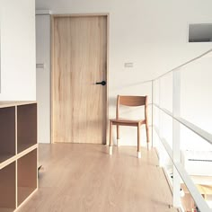 a wooden chair sitting on top of a hard wood floor next to a white wall