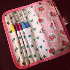 four pens in a pink case with flowers and stars on the side, sitting next to each other